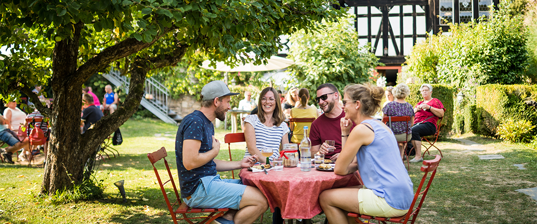 Freunde sitzen am Tisch in der Außengastronomie und essen gemeinsam